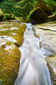 White water current of a stream that flows over rocks and passes between large Foto stock