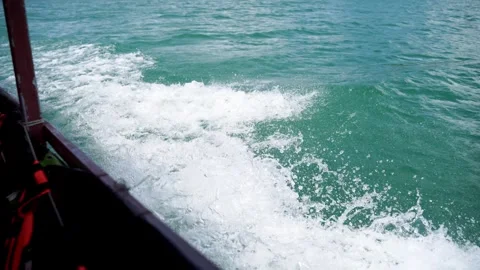 White water splash and wake from a fast moving longtail boat on a green lake. 動画素材 336982830