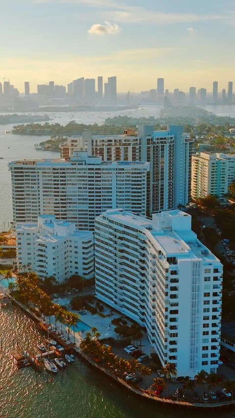 White Waterfront Condo Building With Miami Skyline Backdrop Vertical video. 스톡 동영상 335391990