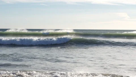 White waves breaking on beach slow motion pan right to left Stock Footage 104686037