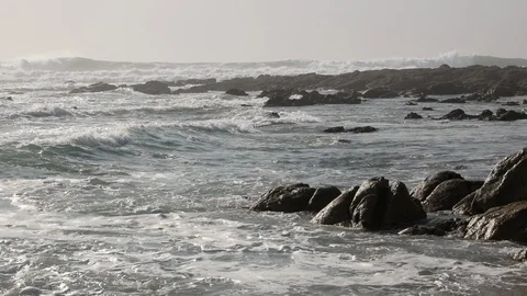 White waves splash against sandstone rocks on the beach with big white waves Stock Footage 103643203