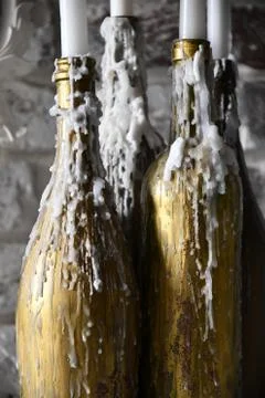 White wax drips solidifies over golden painted bottles Foto stock
