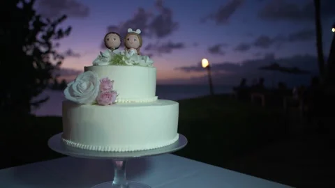 White wedding cake on the beach during sunset in hawaii Stock Footage 136262108