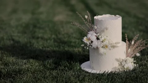 White wedding cake with a decoration of dry flowers on icing in boho style Stock Footage 235470682