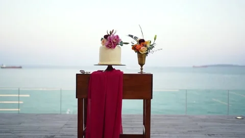 White wedding cake with flowers on the table for beach background. Stock Footage 156339633