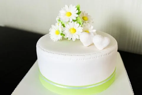 White wedding cake from the mastic with chamomile decor Stock Photos