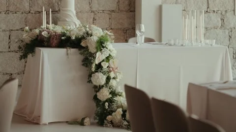 White wedding cake on a round table against stone wall Stock Footage 346110356
