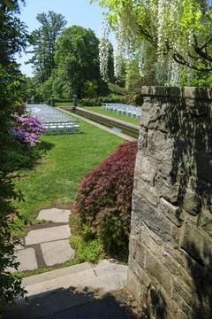 White Wedding Chairs Lined Up before a Real Life Outdoor Summer Wedding Ceremony Stock Photos