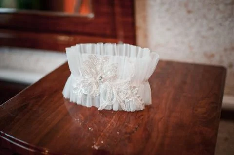 White wedding garter on the table Stock Photos