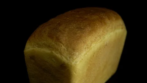White wheat bread turns on a black background, circular motion. Stock Footage 83247165