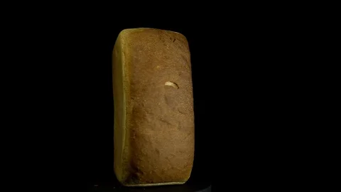 White wheat bread turns on a black background, circular motion. Stock Footage 83247211