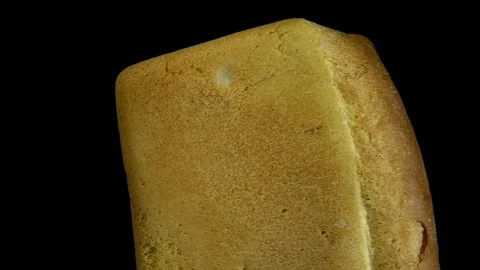 White wheat bread turns on a black background, circular motion. Video stock 83247285