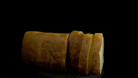 White wheat bread turns on a black background, circular motion. Video stock 83247442