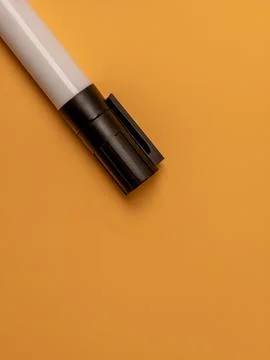 A white whiteboard marker on a solid orange background with copy space 스톡 사진