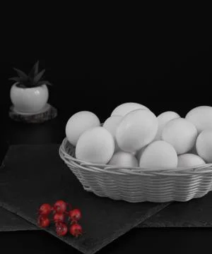 White wicker basket with easter eggs on a black background. Nearby are severa Stock Photos