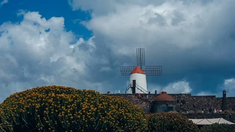 White windmill infront of white clouds in Jardin de Cactus garden of Lanzarote Stock Footage 89144216