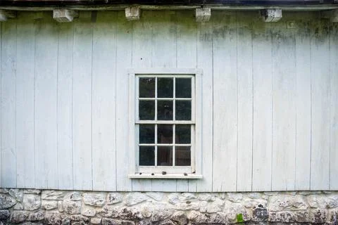 White window in the center of a whitewashed colonial home exterior Stock Photos