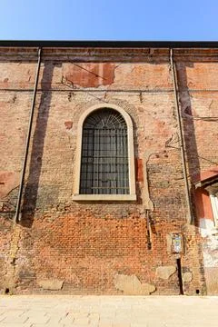 White window on old house wall Cracks in concrete visible red bricks. Stock Photos