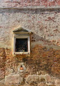 White window on old house wall Cracks in concrete visible red bricks. Stock Photos