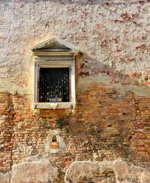 White window on old house wall Cracks in concrete visible red bricks. Stock Photos