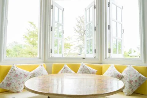 White window with yellow sofa Stock Photos