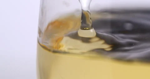 White wine drop falling with splashes in transparent glass in wine cellar Stock Footage 268467323