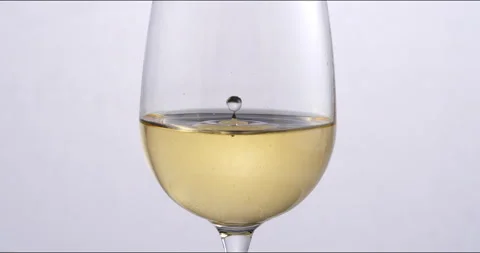 White wine drop falling with splashes in transparent glass in wine cellar Stock-Footage 268801532