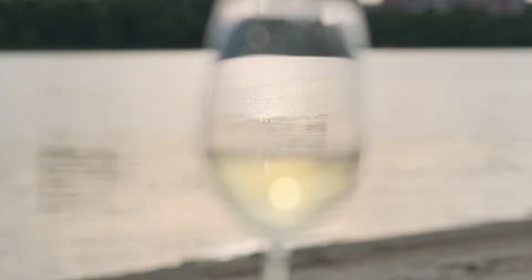 White wine glass liquid reflection. Setting sun water background. Place for text Vídeo Stock 247910368