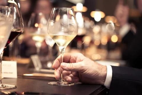 White wine on hand with dinner on restaurant Stock-Fotos