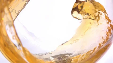 White wine pouring into a glass forms a wave against a white background. Stock Footage 327457411