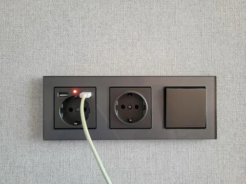 White wire and two sockets and a switch that provide access to electricity on Stock Photos