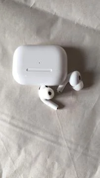 White wireless Bluetooth earphones with charging case on neutral background Stockfoto's