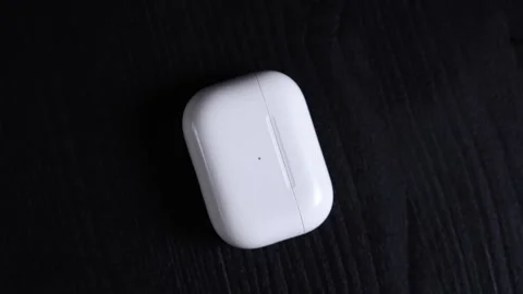 White Wireless Earbud Charging Case on Dark Wooden Surface Stock-Footage 305441239