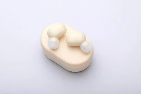 White wireless earbuds on a light background Stock Photos