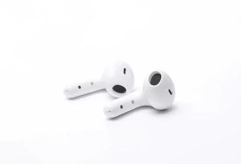 White wireless earbuds on a plain white background Stock Photos