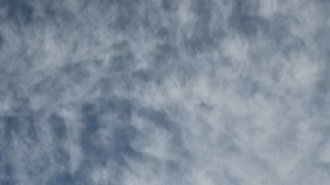 White wispy cirrus clouds move across a blue sky creating an abstract scene.  Stock Footage 141213264