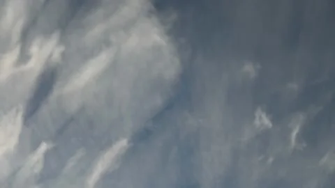 White wispy white and gray cirrus clouds move rapidly across a turquois blue sky Stock Footage 141451252