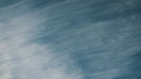 White wispy white cirrus clouds move across a turquois blue sky Stock Footage 141380870