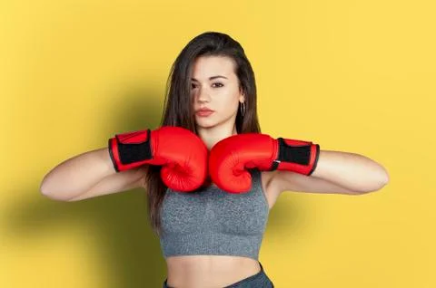 White woman with brown hair practicing boxing on yellow background Stock Photos