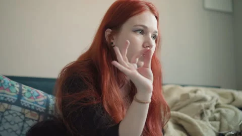 White woman checking lips and notes on phone, rehearsing lines on couch, anxious Stock Footage 346558967