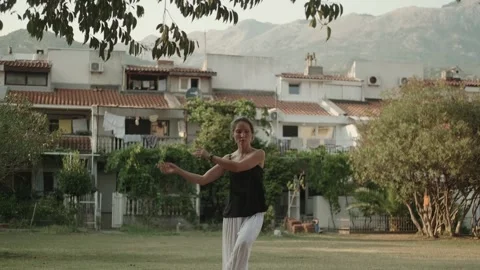 A white woman moves gracefully while doing qigong exercises with mount Video stock 257670372