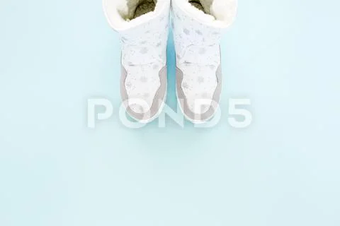White women winter boots isolated on blue background. Flat lay, top view trendy Stock Photos
