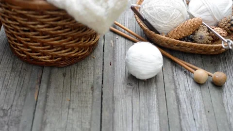 White wool threads roll to basket with knitting on vintage desk Stock Footage 118254408