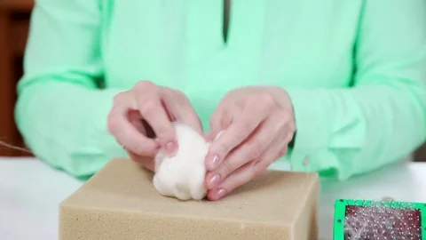 White wool on a wooden stand in front of the needlewoman: dry felting Stock Footage 79406019
