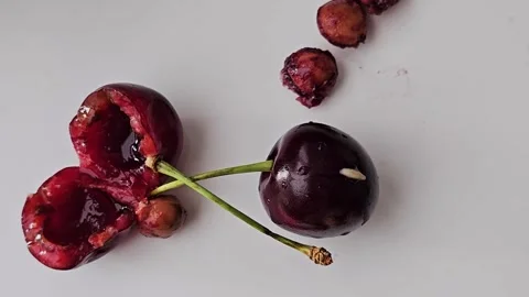 White worms crawl together into the core of ripe red cherry Stock Footage 339184872