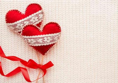 White woven background with two felt hearts with laces, symbol of love. Good Stock Photos