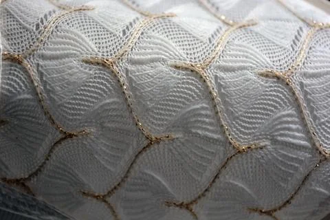 White woven fabric with an pattern of white and fine gold threads. Foto stock