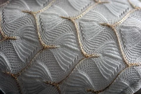 White woven fabric with an pattern of white and fine gold threads. Stock Photos