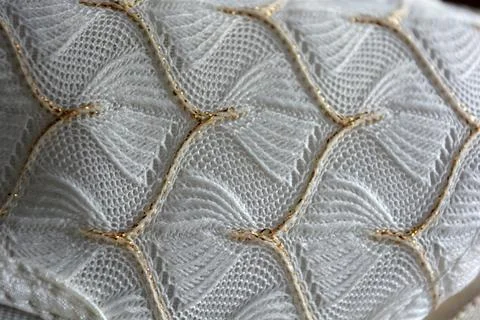 White woven fabric with an pattern of white and fine gold threads. Foto stock