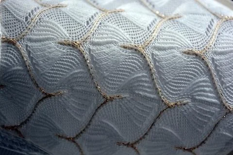 White woven fabric with an pattern of white and fine gold threads. Foto stock